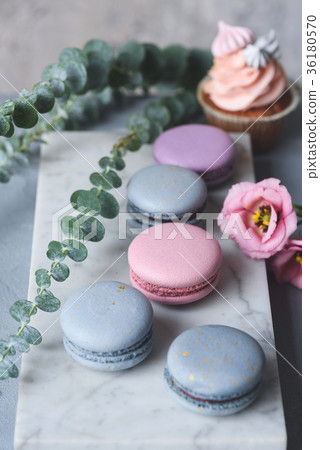 French macaroons and cupcakes with flowers on 36180570