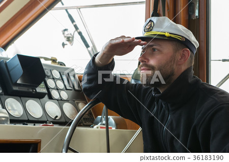 Captain at the helm of boat going along the Captain at the helm of boat going along the 36183190
