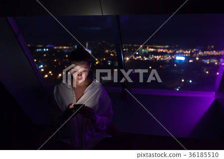Businesswoman uses a smartphone sitting by the 36185510