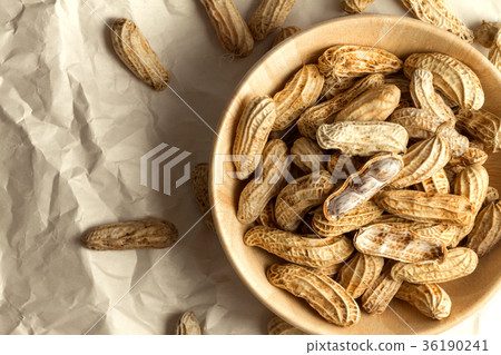 boiled peanuts in wooden cup on crumpled paper 36190241