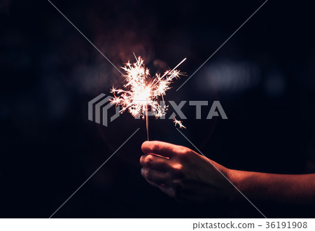 Hand holding burning Sparkler blast on a black Hand holding burning Sparkler blast on a black 36191908