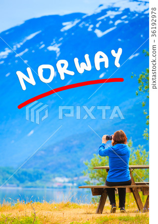 Tourist taking photo at norwegian fjord 36192978