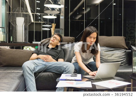 Depressed couple working late in living room at night Depressed couple working late in living room at night 36194552