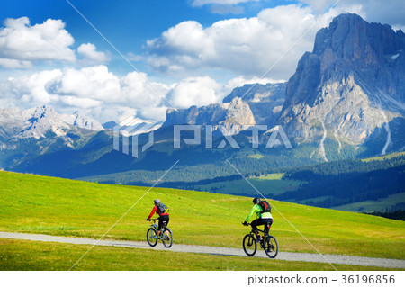 Tourists cycling in Seiser Alm, the largest high altitude Alpine meadow in Europe Tourists cycling in Seiser Alm, the largest high altitude Alpine meadow in Europe 36196856