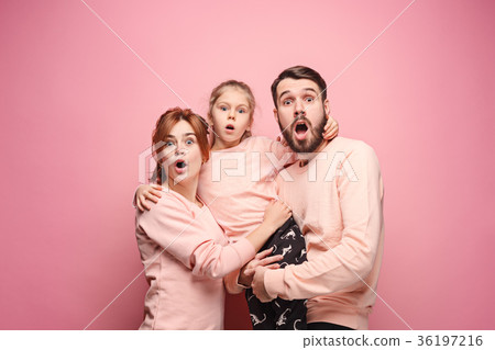 Surprised young family looking at camera on pink Surprised young family looking at camera on pink 36197216