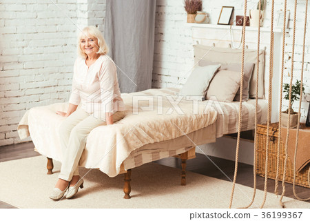 Happy aged pensioner sitting in the bedroom 36199367
