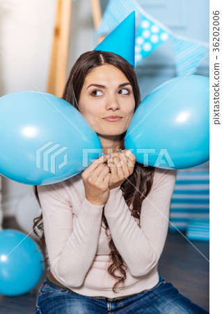 Cheerful woman holding two balloons near her Cheerful woman holding two balloons near her 36202006