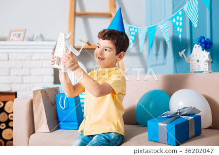 Cute little boy in party hat playing with robot Cute little boy in party hat playing with robot 36202047