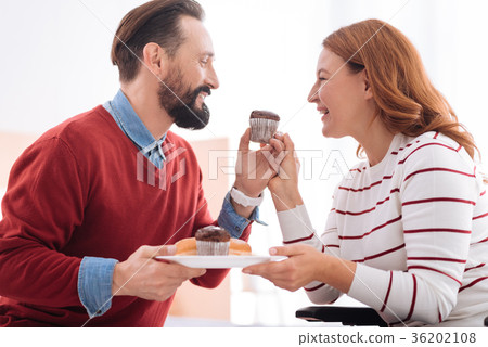Cheerful man and woman having cookies Cheerful man and woman having cookies 36202108