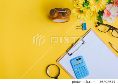 Office equipment on a yellow and golden paper desk 36202635