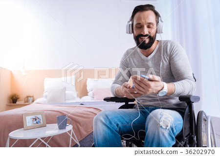 Smiling disabled man listening to music Smiling disabled man listening to music 36202970