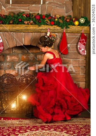 Little winter Princess warms at burning fireplace 36204028