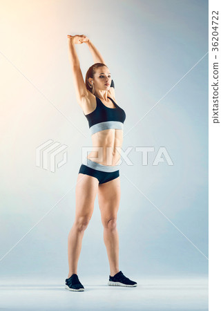 Female athlete stretching arms and back Female athlete stretching arms and back 36204722
