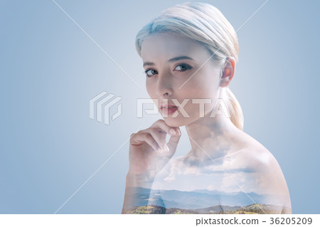 Serious young woman posing against natural Serious young woman posing against natural 36205209