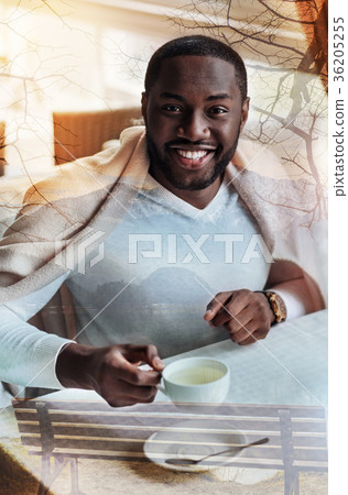 Emotional handsome man looking glad while drinking Emotional handsome man looking glad while drinking 36205255