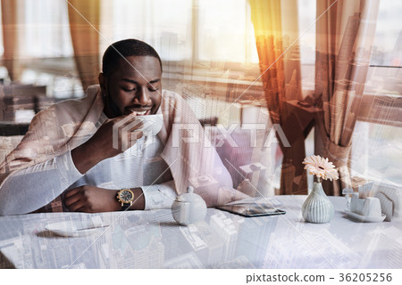 Young cheerful man relaxing in a comfortable cafe Young cheerful man relaxing in a comfortable cafe 36205256