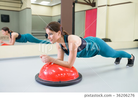 Sport woman exercise with a balance ball at gym Sport woman exercise with a balance ball at gym 36206276