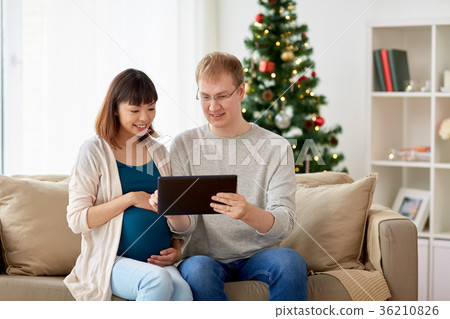 man and pregnant wife with tablet pc at christmas man and pregnant wife with tablet pc at christmas 36210826