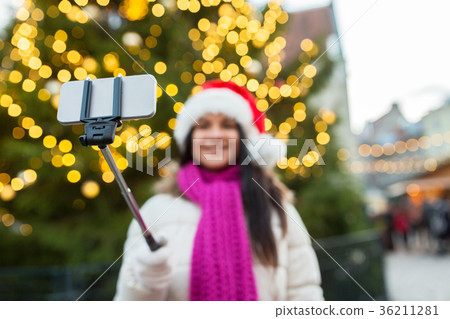 woman taking selfie with smartphone at christmas 36211281