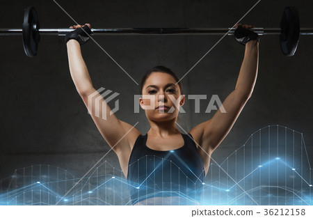 young woman flexing muscles with barbell in gym young woman flexing muscles with barbell in gym 36212158