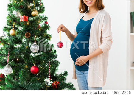 pregnant woman decorating christmas tree 36212706