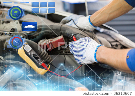 auto mechanic man with multimeter testing battery 36213607