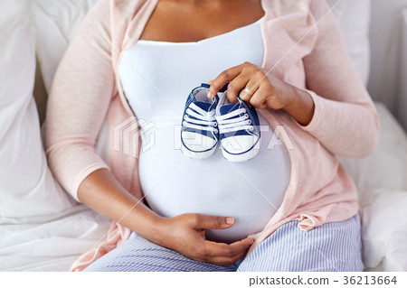 pregnant african woman with baby bootees in bed 36213664