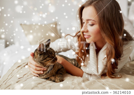 happy young woman with cat lying in bed at home happy young woman with cat lying in bed at home 36214010
