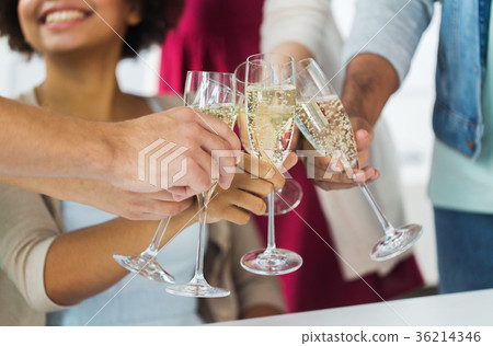 friends clinking glasses of champagne at party 36214346