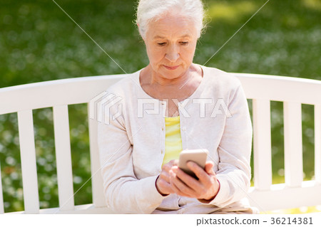 senior woman with smartphone at summer park 36214381