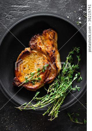 Pork meat, grilled steak on black background Pork meat, grilled steak on black background 36219741