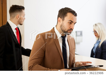 Businessman in office reception area talking with Businessman in office reception area talking with 36222986
