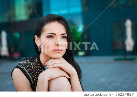 beautiful young lady sitting on the curb 36224927