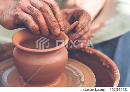 Potter making ceramic pot on the pottery wheel 36234688