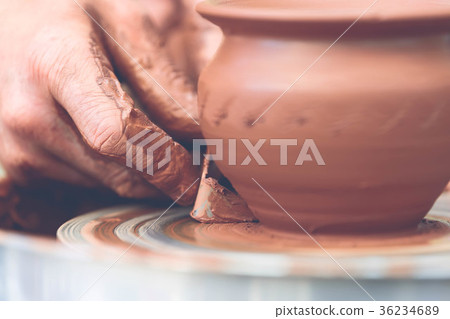 Potter making ceramic pot on the pottery wheel 36234689
