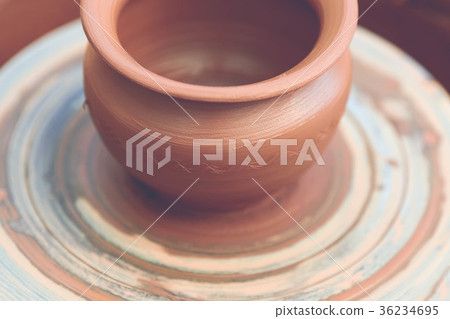 Potter making ceramic pot on the pottery wheel 36234695