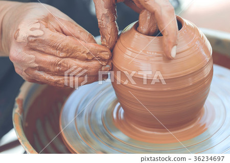 Potter making ceramic pot on the pottery wheel 36234697