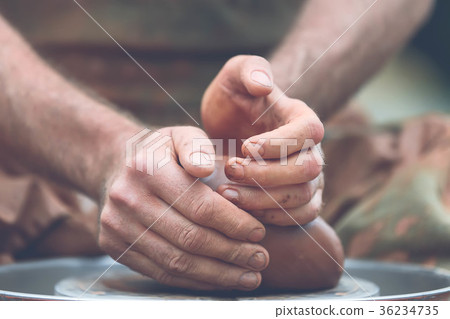 Potter making ceramic pot on the pottery wheel 36234735