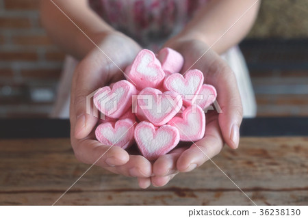 heart shape of pink marshmallow in woman hand 36238130