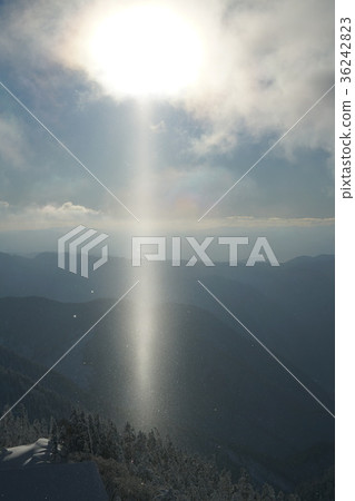 在寒冷的北阿爾卑斯山空氣中跳舞的鑽石塵埃延伸到了太陽柱的位置。 在寒冷的北阿爾卑斯山空氣中跳舞的鑽石塵埃延伸到了太陽柱的位置。 36242823