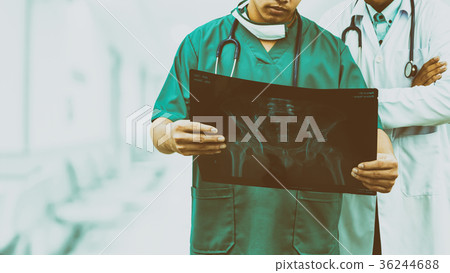 Surgeon and doctor looking at x-ray film. Surgeon and doctor looking at x-ray film. 36244688