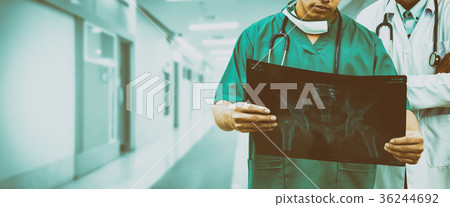 Surgeon and doctor looking at x-ray film. Surgeon and doctor looking at x-ray film. 36244692