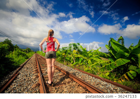 Girl Stands on Railway Track under Clouds Girl Stands on Railway Track under Clouds 36247133