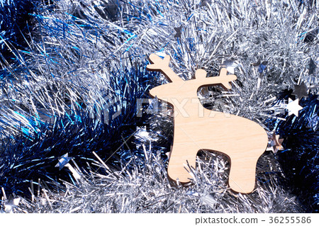 Cut out wooden deer on tinsels background. Cut out wooden deer on tinsels background. 36255586