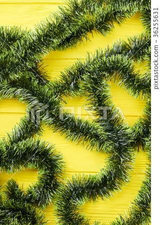 Green Christmas tinsels on wooden background. Green Christmas tinsels on wooden background. 36255631