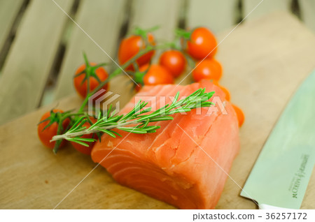 Salmon fillet and cherry tomatoes on cutting board Salmon fillet and cherry tomatoes on cutting board 36257172