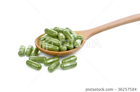 moringa oleifera capsule in wooden spoon isolated  36257584