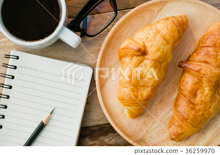 Croissants coffee notebook eyeglasses pencil Croissants coffee notebook eyeglasses pencil 36259970