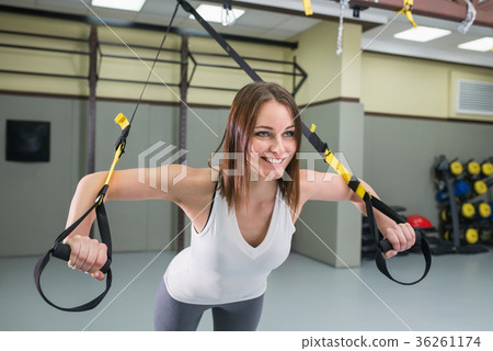 Young happy woman bodybuilder at gym doing elastic 36261174