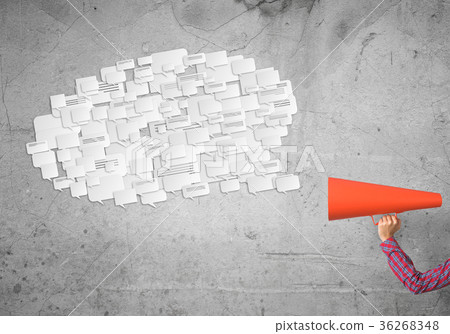 Hand of woman holding red paper trumpet against concrete background 36268348